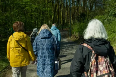 a group of people walking down a dirt road