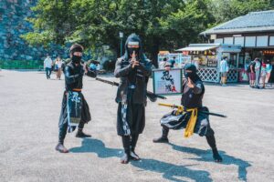 woman in black and white dress holding black and yellow umbrella walking on street during daytime