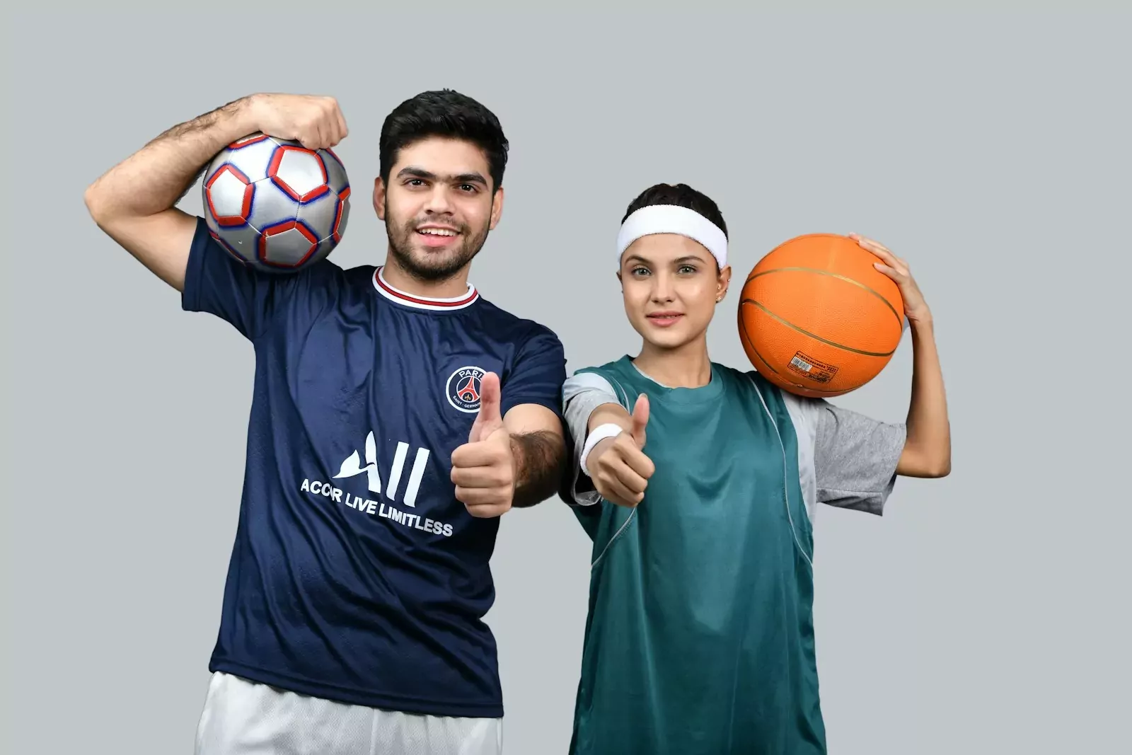 a man and a woman holding a basketball and posing for the camera